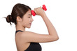 © chaiwat - portrait of pretty sporty girl holding weights