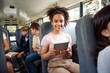 © Viktoriia - Classmates going to school by bus sitting girl close-up using app on digital tablet smiling joyful