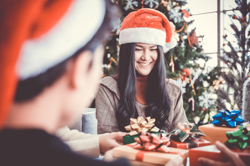 Canvas Print - Asian people party celebrate christmas and new year eve in house. Man and woman giving gift box together