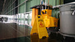 The warning signs cleaning and caution wet floor in the building and janitorial car.