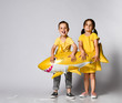 © FAB.1 - Positive little children, dressed in festive clothes, wears a balloon in the shape of a yellow shark fish, celebrates a holiday, has a wide smile, stands on a light background, being in a good mood.