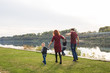 © satura_ - Parent, childhood and nature concept - Family playing with two sons by the water