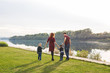 © satura_ - Parent, childhood and nature concept - Family playing with two sons by the water