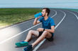 © MarHo - young sportsman in smartwatch sitting on running track and drinking water