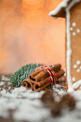 Cinnamon and christmas decoration on wooden table. Spruce branch and snow. Morning in the bright living room. Holiday mood.