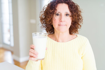 Poster - Senior woman drinking a glass of fresh milk with a confident expression on smart face thinking serious