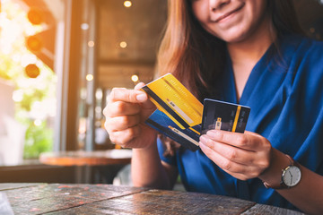 Wall Mural - Closeup image of a woman holding and choosing credit card to use