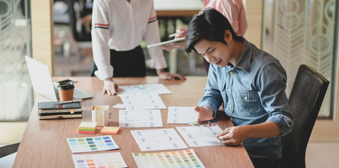 Wall Mural - group of young professional ui graphic designer discussing on their smartphones templates