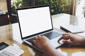 Empty white screen laptop computer on wooden table top, business concept, Notebook mockup design with copy space for text and advertising.