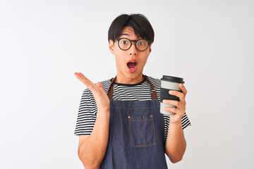 Wall Mural - Chinese barista man wearing apron and glasses holding coffee over isolated white background very happy and excited, winner expression celebrating victory screaming with big smile and raised hands