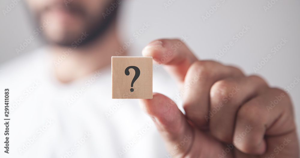 Man showing question mark on wooden cube. - obrazy, fototapety, plakaty 