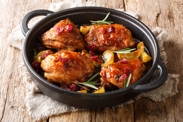 Wall Mural - Holiday food hot baked chicken thighs with apples, cranberries and rosemary closeup in a pan. horizontal