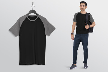 Wall Mural - Hanging black and grey plain raglan t shirt on wall along with male model in blue denim jeans pant. Isolated background