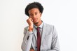 © Krakenimages.com - Young african american businessman wearing suit standing over isolated white background thinking looking tired and bored with depression problems with crossed arms.