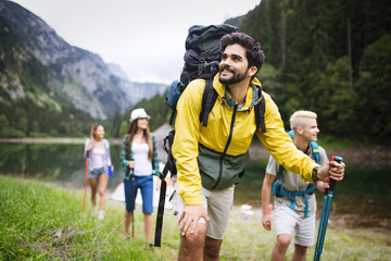 Wall Mural - group of young friends hiking in countryside. multiracial happy people travelling in nature