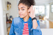 © Krakenimages.com - Beautiful young african american woman with afro hair wearing casual denim jacket smiling with hand over ear listening an hearing to rumor or gossip. Deafness concept.
