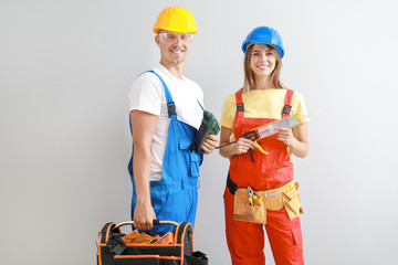 Wall Mural - Happy young couple with tools on light background