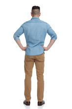 Casual Man Standing With Hands On Waist Pensive