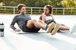 © Drobot Dean - Photo of young cheerful couple doing exercise on mat