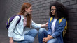 Smiling college student encouraging new classmate taking hand, help assistance