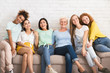 © Prostock-studio - Diverse Women Hugging Sitting On Couch Against White Wall Indoor