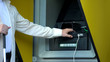 © motortion - Visually impaired man inserting password on atm machine, withdrawing money