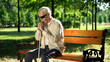 © motortion - Depressed blind man sitting alone in park, socially disadvantaged population
