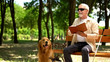 © motortion - Blind man feels happy reading book, resting with dog, socially secure life