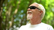 © motortion - Visually impaired man in sunglasses listening nature sounds, heightened senses