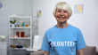 © motortion - Smiling senior lady in volunteer t-shirt looking camera, charity organization