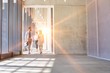 © moodboard - Business people walking in office hall with yellow lens flare in background