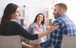 © Prostock-studio - Smiling psychologist looking at happy couple after effective marital therapy