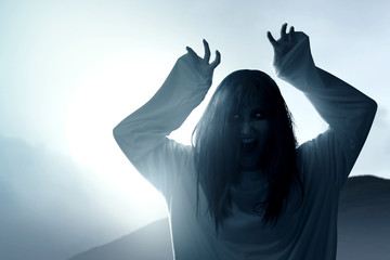 Wall Mural - Scary ghost woman with blood and angry face with clawing hands standing on the grassy field with moonlight