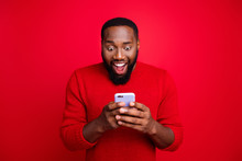 Close-up Portrait Of His He Nice Attractive Focused Cheerful Cheery Glad Excited Bearded Guy Using Wireless Connection App 5g Blog Post Smm Like Isolated Over Bright Vivid Shine Red Background