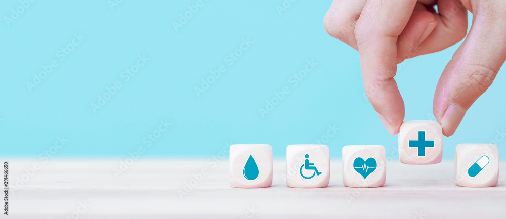 Hand chooses a emoticon icons healthcare medical symbol on wooden block , Healthcare and medical Insurance concept - obrazy, fototapety, plakaty 