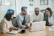 © mavoimages - Diverse business colleagues working with a laptop in an office