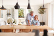 © Monkey Business - Senior Couple Relaxing With Magazine At Home Looking At Mobile Phone Sitting At Dining Room Table