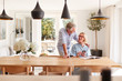 © Monkey Business - Senior Couple Relaxing With Magazine At Home Looking At Mobile Phone Sitting At Dining Room Table