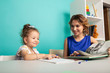 © burdun - Mom with little baby girl together at home sitting at the table