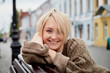© keleny - Blonde funny pretty girl sitting on bench in Central part of old city. Walk in downtown. Portrait of girl on street