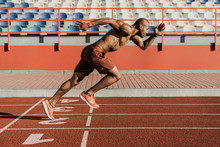 Side View Of An Athlete Starting His Sprint On An All-weather Running Track