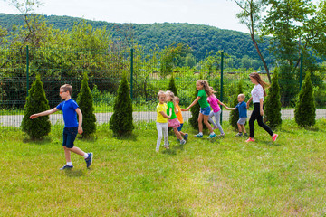 Wall Mural - Tutor girl walk with children, summer day