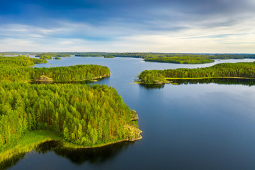 Canvas Print - Aerial view of of small islands on a blue lake Saimaa. Landscape with drone. Blue lakes, islands and green forests from above on a cloudy summer morning. Lake landscape in Finland.