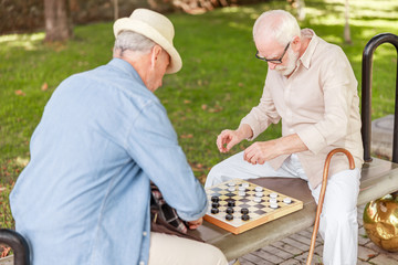 Two senior men playing checkers in the park