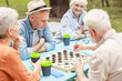 © Yakobchuk Olena - Senior people playing checkers in the park