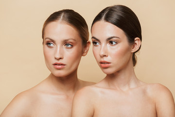 Poster - Women posing naked isolated over beige wall background.