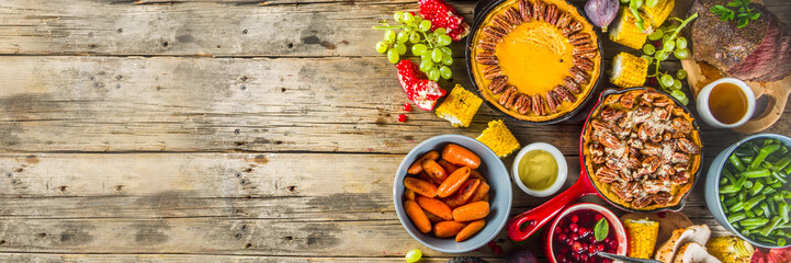 Thanksgiving family dinner setting concept. Traditional Thanksgiving day food  with turkey, green beans and mashed potatoes, stuffing, pumpkin, apple and pecan pies, rustic wooden table