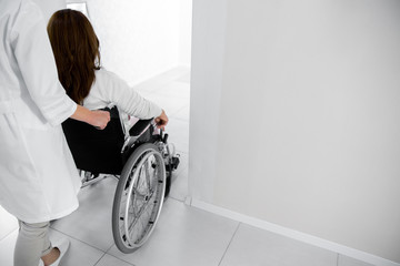 Wall Mural - Nurse helping for female patient on wheelchair