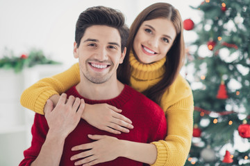 Close up photo of two spouses people have romance enjoy christmas vacation newyear party hug piggyback in house with xmas ornament indoors