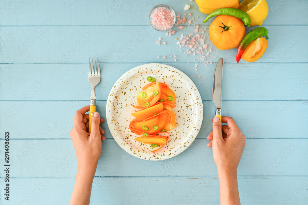 Woman eating tasty salad at table, top view